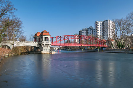 Berlin, Germany - February 23, 2021: Heritage-protected steel truss Haven bridge (Sechserbruecke) over the frozen stream Tegeler Fliess with its pavilion-like gate and two ticket boothsのeditorial素材