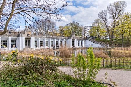 Berlin, Germany - April 25, 2021: Garden monument Rudolph Wilde Park with the duck pond and the Carl-Zuckmayer bridge with the above-ground subway station Rathaus Schoenebergのeditorial素材