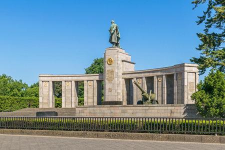Soviet War Memorial, a curved stoa topped by a statue of a Soviet soldier and a Cyrillic inscription "Eternal glory to heroes who fell in battle ..." and a Red Army ML-20 gun-howitzer artillery pieceのeditorial素材