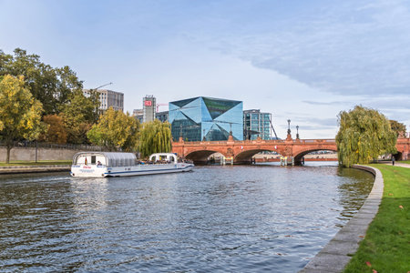 Berlin, Germany - October 18, 2021: River Spree with the Moltke Bridge, tourist sightseeing boat, a cube-shaped office building on Washingtonplatz, the Cube Berlin, and Hauptbahnhofのeditorial素材
