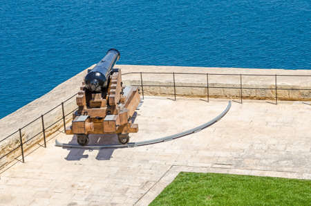 One of the ceremonial guns of the Saluting Battery which fire gun signals daily, as seen from the Upper Barrakka Gardens in Valletta, Malta.の写真素材