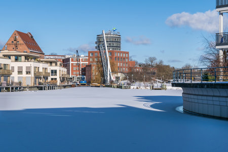 Berlin, Germany - February 12, 2021: Frozen Harbor basin Tegeler Hafen with the footbridge, old and modern buildings, residential units and the clinic Medical Park Humboldtmuehleのeditorial素材