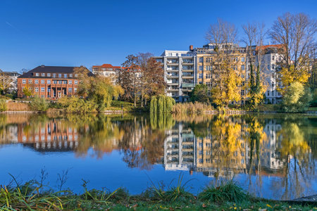 Berlin, Germany - November 7, 2020: Park and a listed garden Lietzensee and buildings on the shore of Lake Lietzen (Media House to the left) with its facades reflecting in the waterのeditorial素材