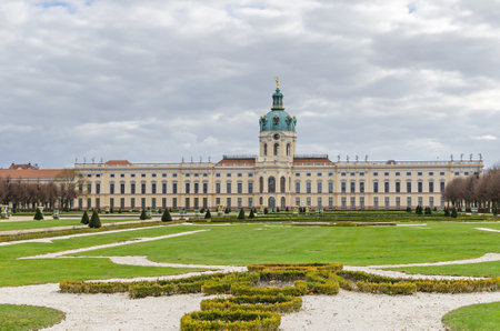 Berlin, Germany - March 19, 2019: Charlottenburg Palace with its domed tower, a wind vane in the form of a gilded statue representing Fortune, statues on the cornice and a large formal gardenのeditorial素材