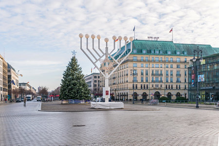Berlin, Germany - December 18, 2020: Historic square Pariser Platz with the Hotel Adlon, largest Hanukkah candlestick in Europe and a decorated Christmas treeのeditorial素材