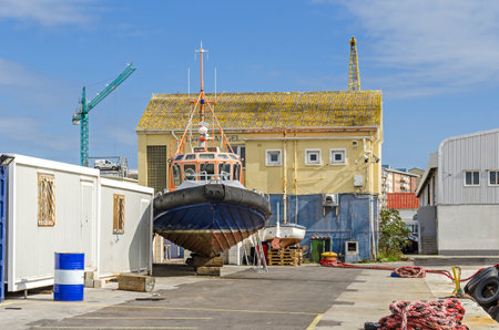 Gibraltar, British Overseas Territory - November 8, 2018: Harbor with a towboat, old port building and cranesのeditorial素材