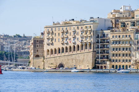 Senglea, Malta - June 4, 2017:  Senglea waterfront as seen from the Grand Harbour, its modern part with limestone buildings adapted to the old maltese architectural styleのeditorial素材