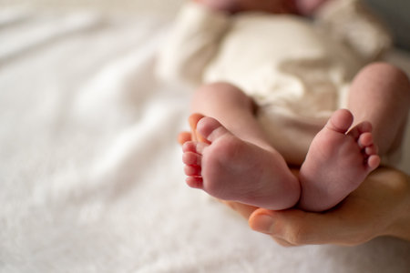 Close-up view of a baby feet held by her mom. copy space