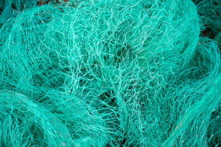 Close-up view of a green fishing net. Waste in nature. Environmental protection.の写真素材