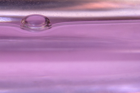 Beautiful drop of water on abstract pink bokeh background, super macro.の写真素材