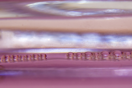 Beautiful drops of water  in a row on a gentle pink background. Abstract background with shallow depth of field.の写真素材