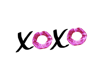 Black handwritten text XOXO with red lipstick imprints isolated on white background. Design element for posters, greeting cards with a kiss on Valentine's Day or wedding.の写真素材