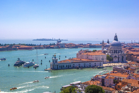 Panorama  of Italian houses with red tiled roofs, Adriatic sea and Grand Canal with boats and gondolas, ships and boats, romantic city on water, Venice, Italy. Top view.の写真素材