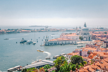 Panoramic view of Venice - Grand Canal with gondolas, Basilica Santa Maria della Salute and red tiled roofs of houses, Venice, Italyの写真素材