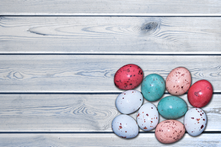 Colorful easter eggs on a white wooden table, Easter concept with space for text. Top view.の写真素材