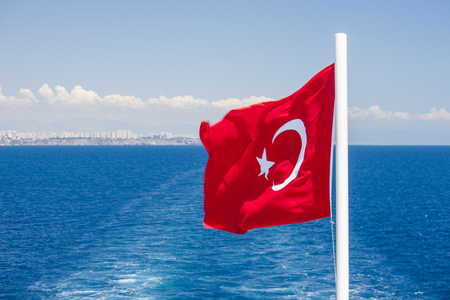 Red Turkish flag and keel water, trace on surface of sea in Mediterranean.の写真素材