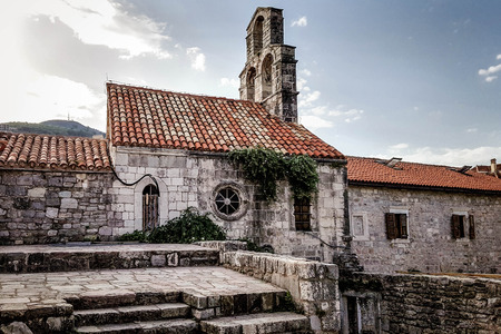 Old stone church, stable with a red tiled roof in Old Town, Budva, Montenegro