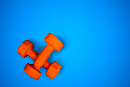Two orange dumbbells, fitness equipment isolated on blue background, top view, flat lay, copy scpaceの写真素材