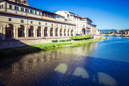 Panoramic view of  Arno River, Vasari Corridor and reflection stone medieval bridge Ponte Vecchio, Florence, Tuscany, Italy.の写真素材