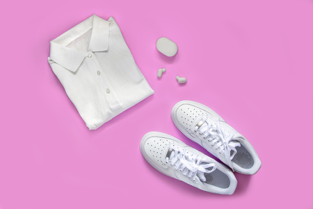 Sport set, fitness accessories flat lay on pink background. White fashion footwear, earphones, T-shirt for body workout, top view. Active life concept.の写真素材