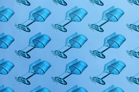 Empty wine glasses with shadow on blue background. Minimal style pattern. Art design. Top view, flat lay.の写真素材