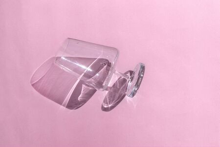 Empty wine glass with shadow on pink background. Minimal style. Art design. Top view, flat lay.の写真素材