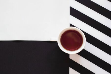 Cup of coffee / tea on black and white table with stripes in minimal style. Top view, flat lay with copy space.の写真素材