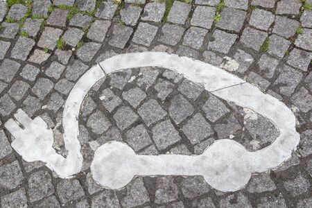 Electric vehicle charging station sign in parking cars on paved city roadの写真素材