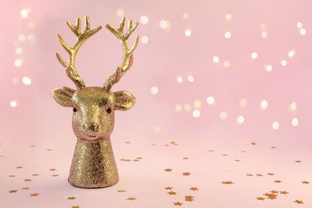 Christmas composition in minimal style - golden deer head on pink background with New Year lights, copy spaceの写真素材