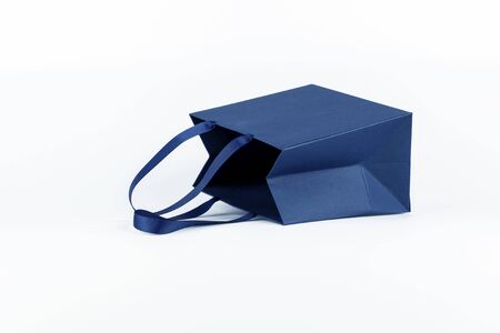 Gift paper bag, shopping bag in classic blue color isolated on white background. Mockup of blank craft package. Concept for presents holidays, father's dayの写真素材