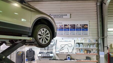 ST. PETERSBURG, RUSSIA - JUNE 17, 2019: Car in repair station, body shop on hydraulic lifts in modern automotive dealership maintenance garage.のeditorial素材