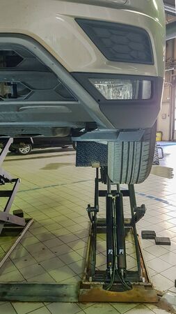 ST. PETERSBURG, RUSSIA - JUNE 17, 2019: Car in repair station, body shop on hydraulic lifts in modern automotive dealership maintenance garage.のeditorial素材
