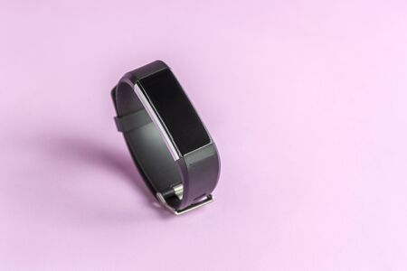 Activity smart tracker on light pink background. Black fitness health watch, sport braceletの写真素材