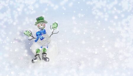 Happy snowman in stylish hat and scarf in winter new year landscape. Beautiful festive Christmas snowy background, banner format, copy space.の写真素材