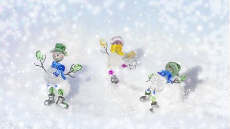 Funny snowmen carefree on snow in winter new year landscape. Beautiful bokeh circles Christmas snowy background, banner format, copy space.の写真素材