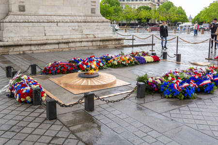 PARIS, FRANCE - MAY 8, 2019: Flowers and eternal flame near Arc de Triomphe in honor of victory over...