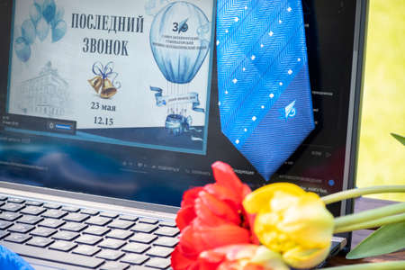 ST. PETERSBURG, RUSSIA - MAY 23, 2020: High school graduation in online. Last Call  in Russian in laptop, flowers and school tieのeditorial素材