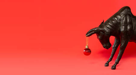 Ox with Christmas ball on horns on red background, banner. Buffalo, bull as symbol of year 2021 to Chinese calendar. Merry christmas and new year greeting cardの写真素材