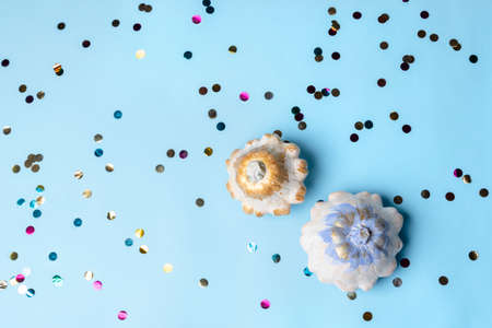 Halloween decoration with white pumpkins and colorful confetti on blue background. Thanksgiving...