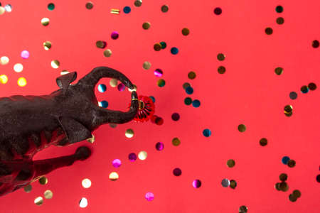 Ox with Christmas ball on horns on red