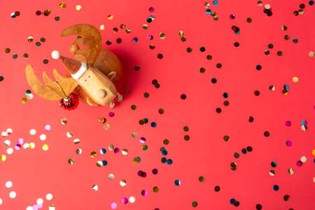 Christmas bauble deer and colorful shiny confetti on red background. Happy New Year celebration....