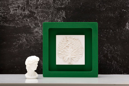 Stylish living room interior with botanical bas-relief cabbage leaf and statuette head of David for...