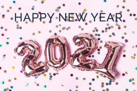Gold pink balloons in form of numbers 2021 with colorful shiny confetti on pink background. Happy New Year 2021 celebration. Flat lay, top view.の写真素材