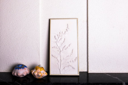 Stylish living room interior with botanical bas-relief wildflowers for wall art and white gold...