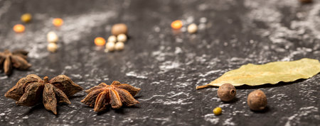 Anise stars Illicium verum, black peppercorns on black stone background. Selective focus, bannerの写真素材