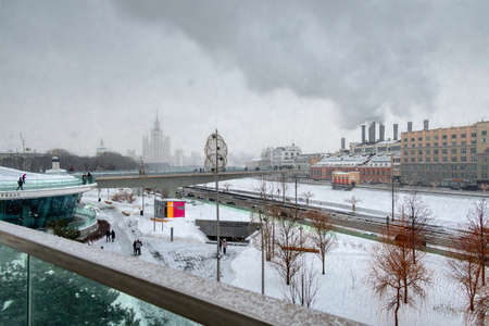 Floating pedestrian bridge in Zaryadye Park above Moskva River, Kotelnicheskaya Embankment Building in snowy winter, Moscow, Russiaのeditorial素材