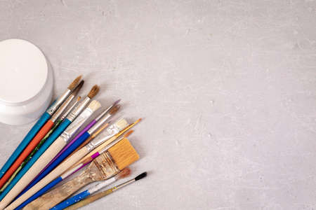 Professional dirty working artist brushes and paint on marble table. Flat lay, top view.の写真素材