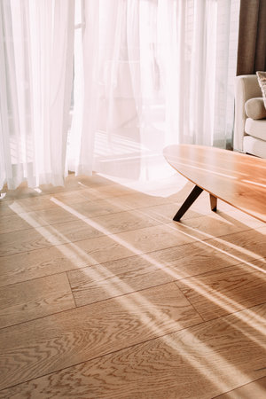 Modern room interior with an open window in minimal style. Transparent tulle with morning sun rays...