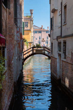 View of architecture and arch bridge of Venice from Grand Canal. Beautiful colorful houses on narrow water streets with reflection, Venice, Italy.の写真素材