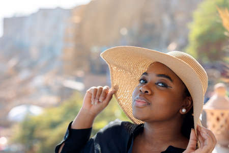 Portrait of beautiful African American model girl in stylish sun hat. Fashion black woman on natural background coast of sea.の写真素材